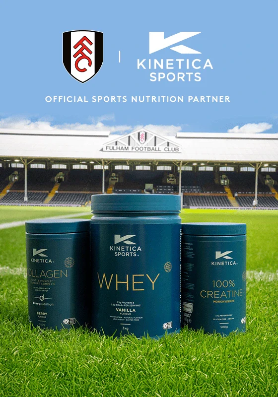 Kinetica Sports protein powder containers on a grass field with Fulham Football Club stadium in the background